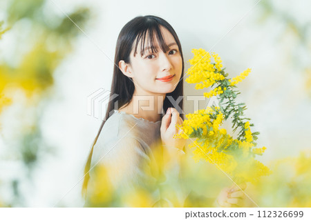 Young woman with mimosa flowers 112326699