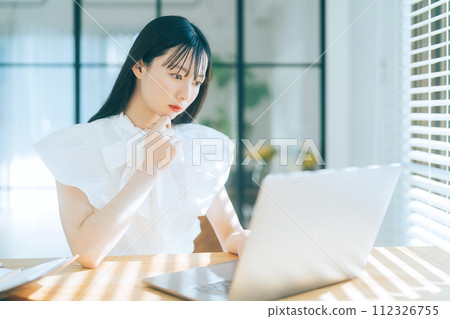 Young woman using a personal computer Young woman using a personal computer 112326755