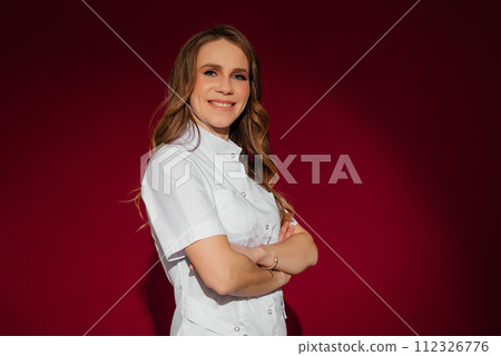 Confident female doctor wearing white suite standing on red background. Confident female doctor wearing white suite standing on red background. 112326776