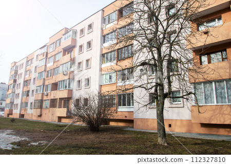 Windows of multi-storey tall building against background of sky 112327810