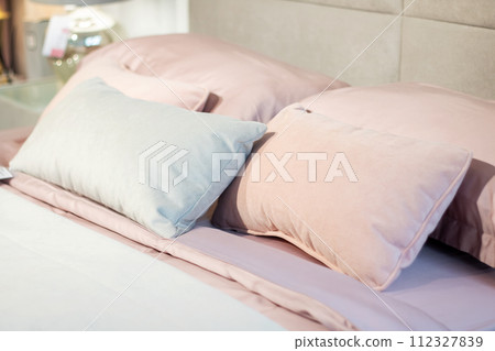 Soft pillows on a large bed in pastel colors Soft pillows on a large bed in pastel colors 112327839