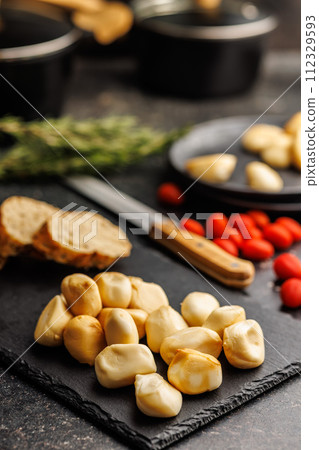 Smoked mini scamorza cheese. Traditional italian cheese on cutting board on black table. 112329593