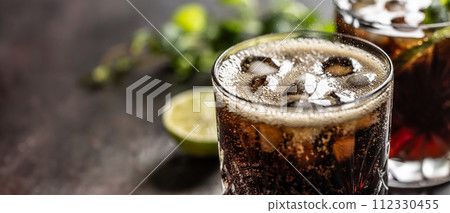 Bubbling Coke drink with ice cubes on the bar counter. 112330455
