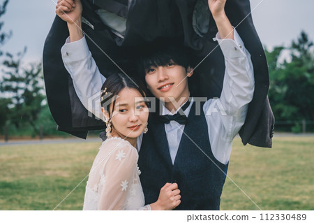 Man and woman cuddling outdoors in the rain 112330489