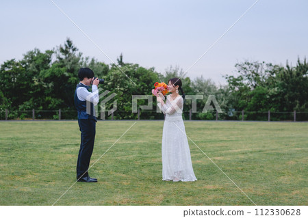 新郎在公園給新娘拍照 112330628