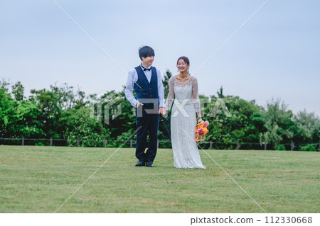 Bride and groom holding hands in the park Bride and groom holding hands in the park 112330668