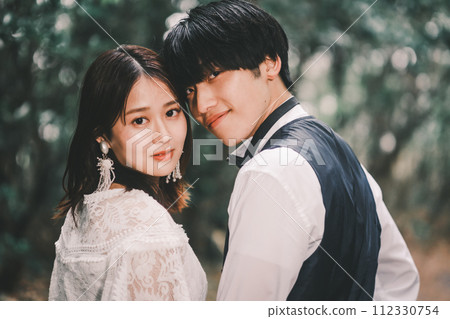 Bride and groom cuddling in the woods 112330754