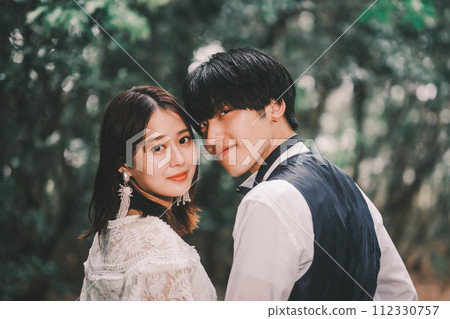 Bride and groom cuddling in the woods Bride and groom cuddling in the woods 112330757