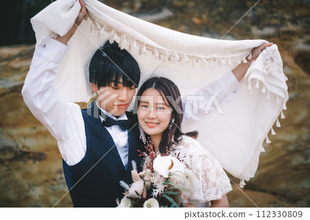 新娘和新郎依偎在一塊石頭上 112330809