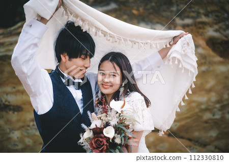 新娘和新郎依偎在一塊石頭上 新娘和新郎依偎在一塊石頭上 112330810