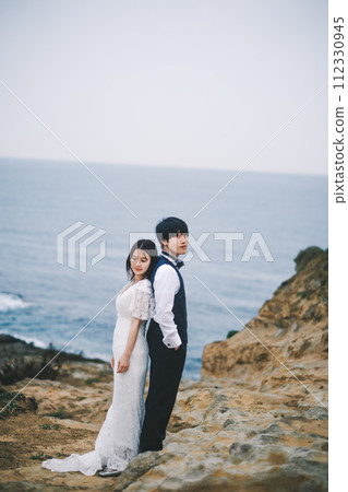 bride and groom cuddling on the beach 112330945