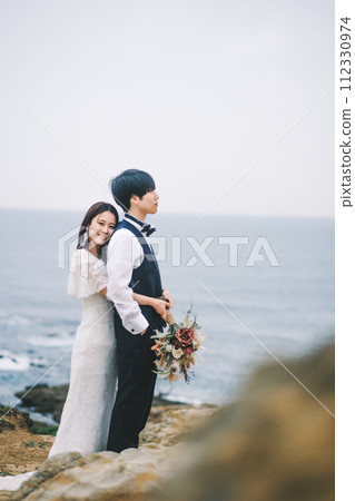 新娘和新郎在沙灘上依偎 新娘和新郎在沙灘上依偎 112330974