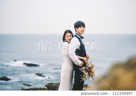 新娘和新郎在沙灘上依偎 新娘和新郎在沙灘上依偎 112330997