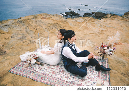 新娘和新郎背靠背坐在沙灘上 新娘和新郎背靠背坐在沙灘上 112331050