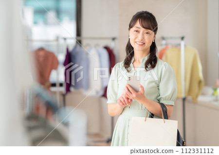 一位中年婦女在商店購物時操作智能手機 112331112