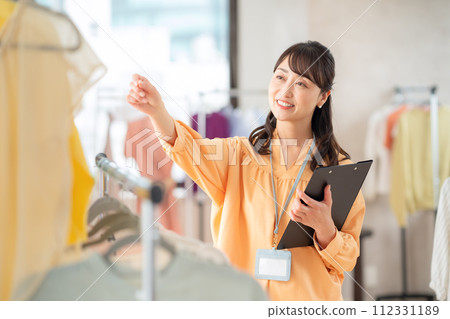 A middle-aged female clerk working at an apparel shop 112331189