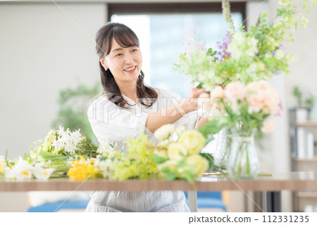 A middle-aged woman who makes a hobby flower arrangement in the living room 112331235