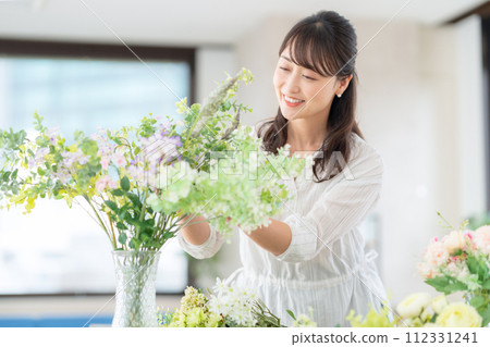 A middle-aged woman who makes a hobby flower arrangement in the living room 112331241