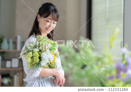 A middle-aged woman who makes a hobby flower arrangement in the living room 112331260
