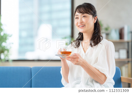 中年婦女在客廳喝茶 112331309