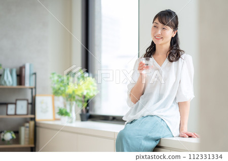 中年婦女在客廳喝水 112331334