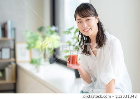 中年婦女在客廳喝番茄汁 112331348