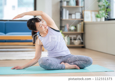 Middle-aged woman doing yoga in the living room Middle-aged woman doing yoga in the living room 112331373