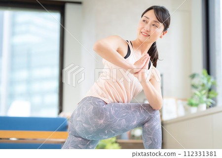Middle-aged woman doing yoga in the living room 112331381