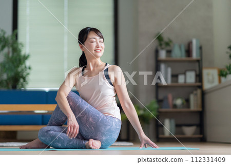 Middle-aged woman doing yoga in the living room Middle-aged woman doing yoga in the living room 112331409