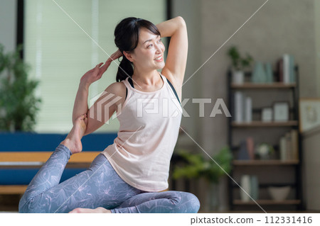 Middle-aged woman doing yoga in the living room Middle-aged woman doing yoga in the living room 112331416