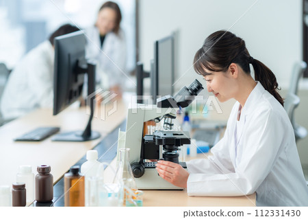 一位中年婦女在顯微鏡下進行研究和實驗 112331430