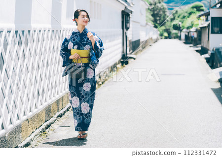 A woman in a yukata walking around the castle town of Hagi A woman in a yukata walking around the castle town of Hagi 112331472