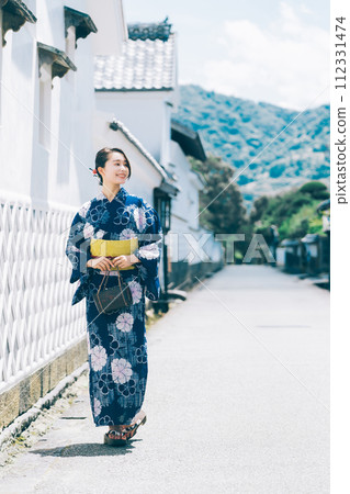 A woman in a yukata walking around the castle town of Hagi 112331474
