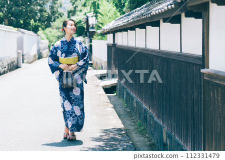 A woman in a yukata walking around the castle town of Hagi A woman in a yukata walking around the castle town of Hagi 112331479