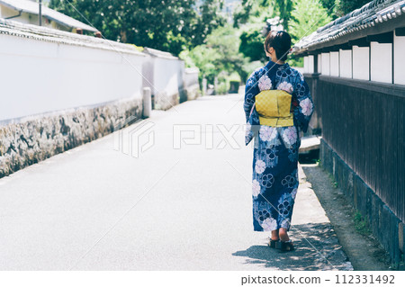 A woman in a yukata walking around the castle town of Hagi A woman in a yukata walking around the castle town of Hagi 112331492