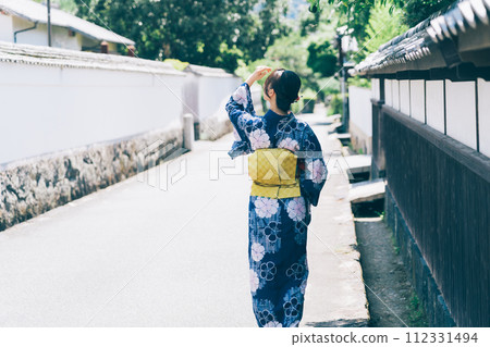 A woman in a yukata walking around the castle town of Hagi A woman in a yukata walking around the castle town of Hagi 112331494