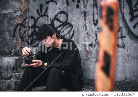 A man sitting down and checking the photos he took A man sitting down and checking the photos he took 112331564