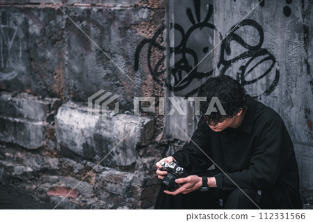 一個男人坐下來檢查他拍的照片 112331566
