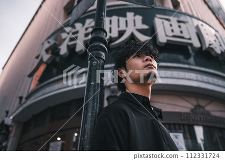 A man waiting in front of a retro building 112331724