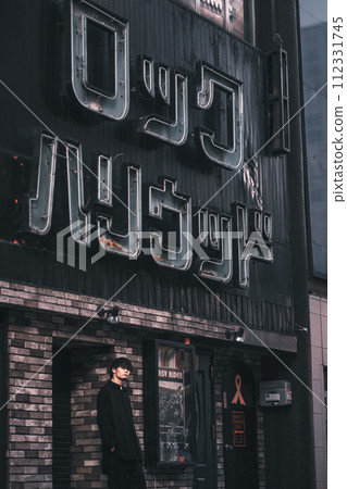 A man waiting in front of a retro building A man waiting in front of a retro building 112331745