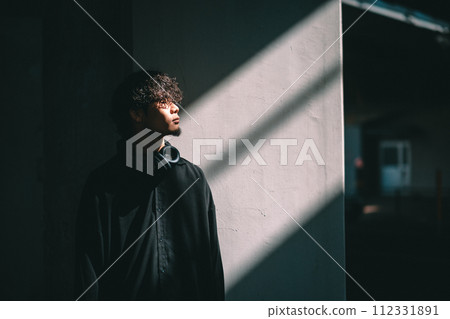 站在有光的牆前的人 112331891