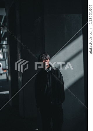 man standing in front of a wall with light man standing in front of a wall with light 112331905