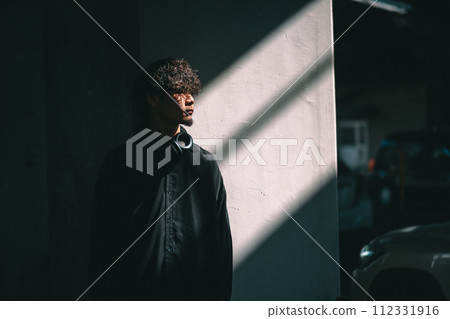 man standing in front of a wall with light 112331916