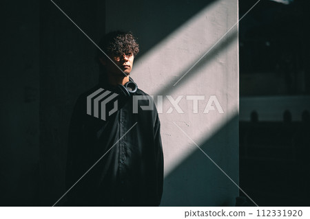 man standing in front of a wall with light 112331920