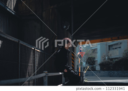 man sitting under an overpass 112331941