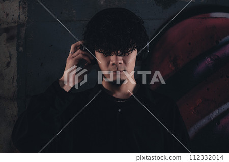 A man wearing headphones under an overpass A man wearing headphones under an overpass 112332014