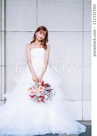 Bride standing in front of a white wall Bride standing in front of a white wall 112332560