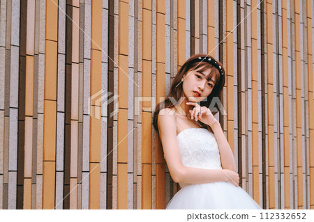 穿著婚紗的新娘在五顏六色的牆前擺姿勢 穿著婚紗的新娘在五顏六色的牆前擺姿勢 112332652