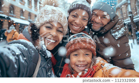 Happy family having fun and smiling at the camera in the snowy winter. 112332806