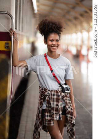 Young Asian African woman traveler with backpack in the railway train station, traveler girl walking stand sit waiting take a picture on railway platform train station. High quality photo Young Asian African woman traveler with backpack in the railway train station, traveler girl walking stand sit waiting take a picture on railway platform train station. High quality photo 112333358